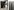 Pivothaustür mit NEOLITH Nero-Zimbabwe-Riverwashed FUSION collection (C16) aus einem Stück) belegt mit passendem Stoßgriff ROUND 2000mm in PVD Schwarz