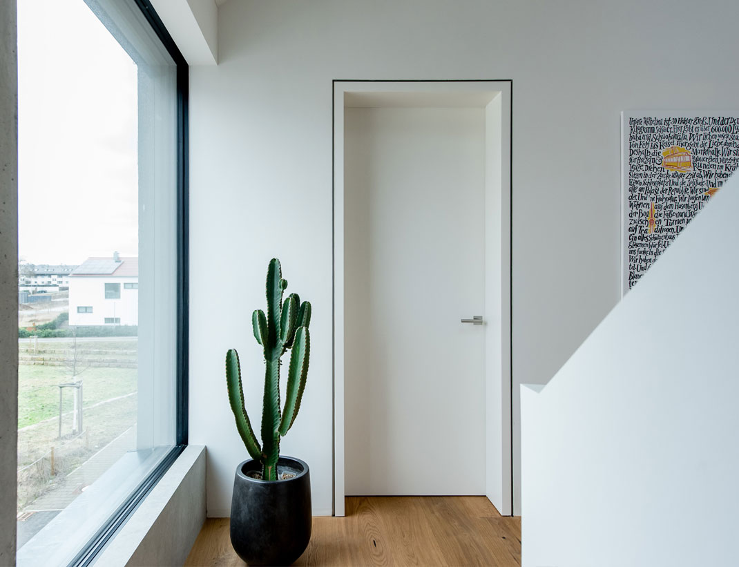 Wandbündige Tür INTRA UZ-ALU (Unterzarge mit Aluprofil) in Schleiflack Reinweiß RAL 9010 ohne Schlüssellochbohrung (Projekt Architektenhaus Stuttgart).