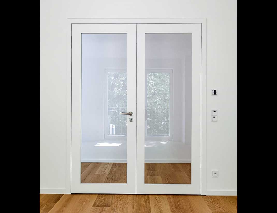2-flüglige, flächenbündige Tür mit großem Lichtausschnitt mit Klarglas und passenden Sockelleisten