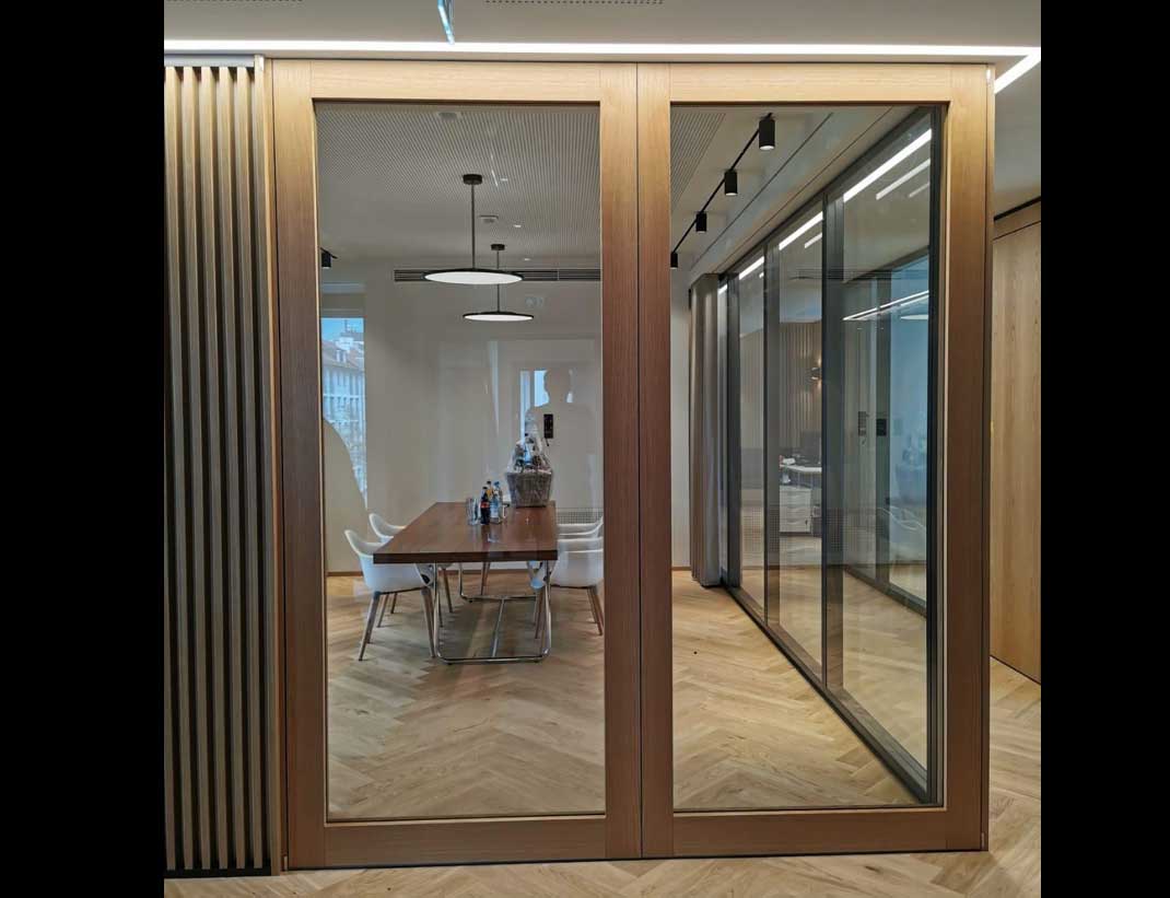 2-flüglige Pivot Glastür SVING-GLAS als Raumteiler für einen Konferenzraum in Eiche
